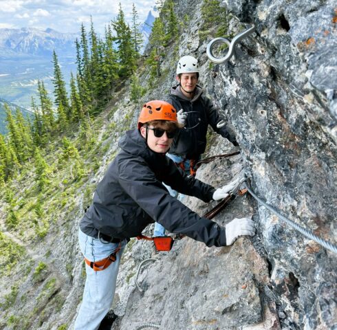 Kinderen klimmen op de rotsen bij de Via Ferrata in Banff