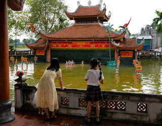 Moeder en kind aan waterpoppentheater bij Hanoi