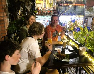 Ouders en kinderen genieten op terras in Hanoi