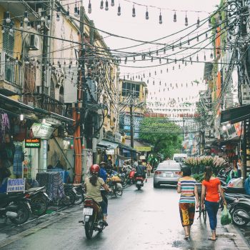 Wandelaars en brommers in Hanoi Vietnam