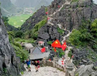 Familie klimt op trappen van Drakenberg bij Mua Cave in Ninh Binh