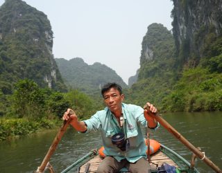 Schipper op boottocht in Trang An