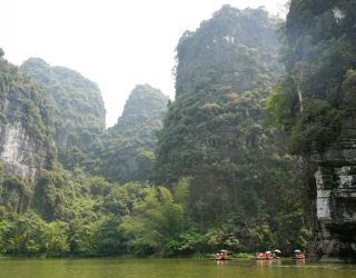 Varen op rivier tussen karstgebergte bij Ninh Binh