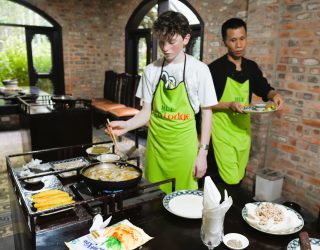 Tiener kookt gevulde pannenkoeken in Hué Vietnam