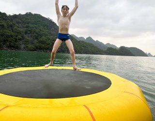 Kind op springkussen in azuurblauw water Halong Bay Vietnam