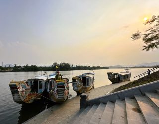 Drakenboten op de parfumrivier in Hué bij zonsondergang