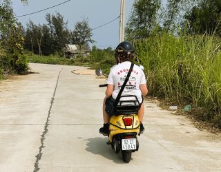 Kind achterop elektrische scooter bij Hoi An Vietnam