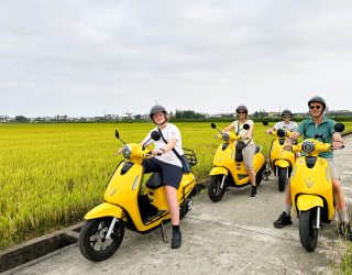 Familie zoeft door de rijstvelden op elektrische scooters