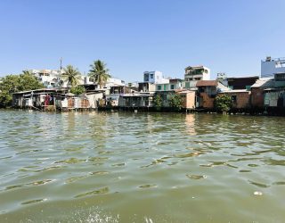 Varen met de kinderen langs de huizen in Mekong Delta