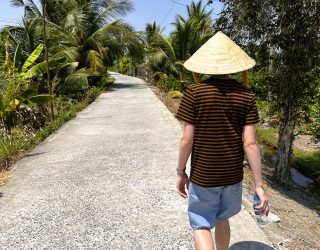 Kind wandelt in lokaal dorpje in groene Mekong Delta