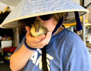 Kind met eend op de markt in Mekong Delta