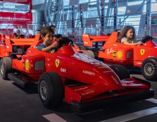 Kinnderen in auto's in pretpark Ferrari World Abu Dhabi