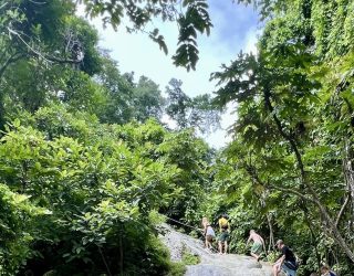 Familie klimt op Sticky Waterfalls in Chiang Mai Thailand