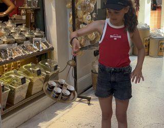 Tiener zwaait met kopjes thee op Grieks dienblad