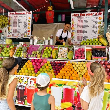 Kinderen drinken smoothie op Djemaa el Fna plein Marrakech