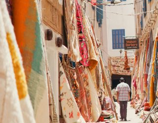 Man wandelt tussen tapijten in Essaouira