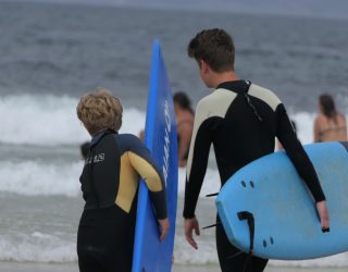 2 jongens op het strand met hun surfplank in Portugal