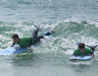 2 kinderen surfen op de golven in Portugal