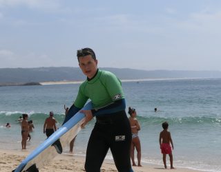 Jongen houdt surfplank vast in Portugal