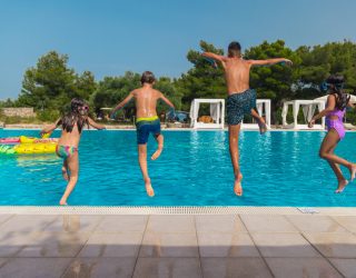 Kinderen springen in het zwembad